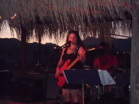 Kiri Mariposa Hall performing live at sunset under a palapa